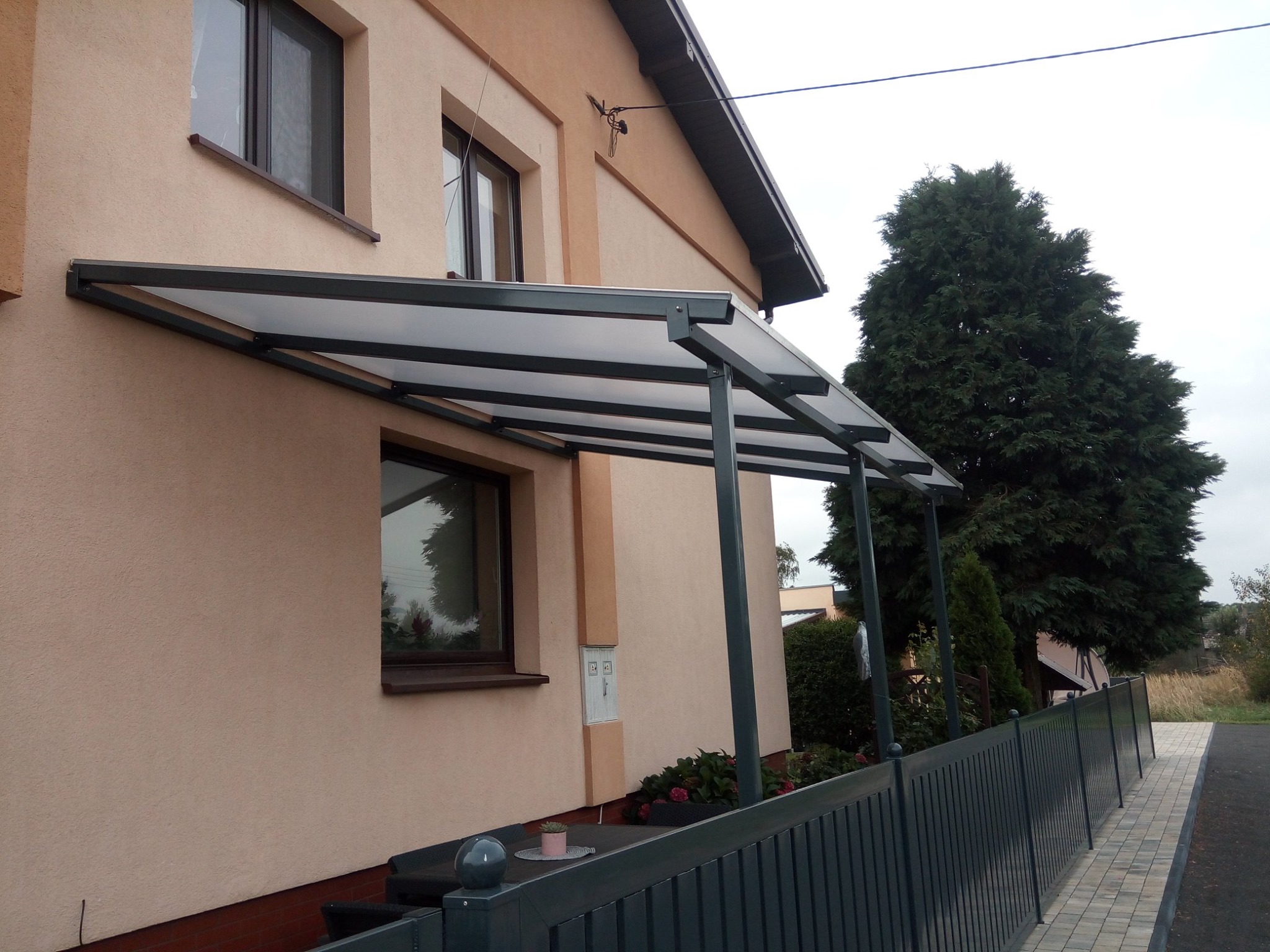 Metalowe zadaszenie tarasu z poszyciem z poliwęglanu mlecznego