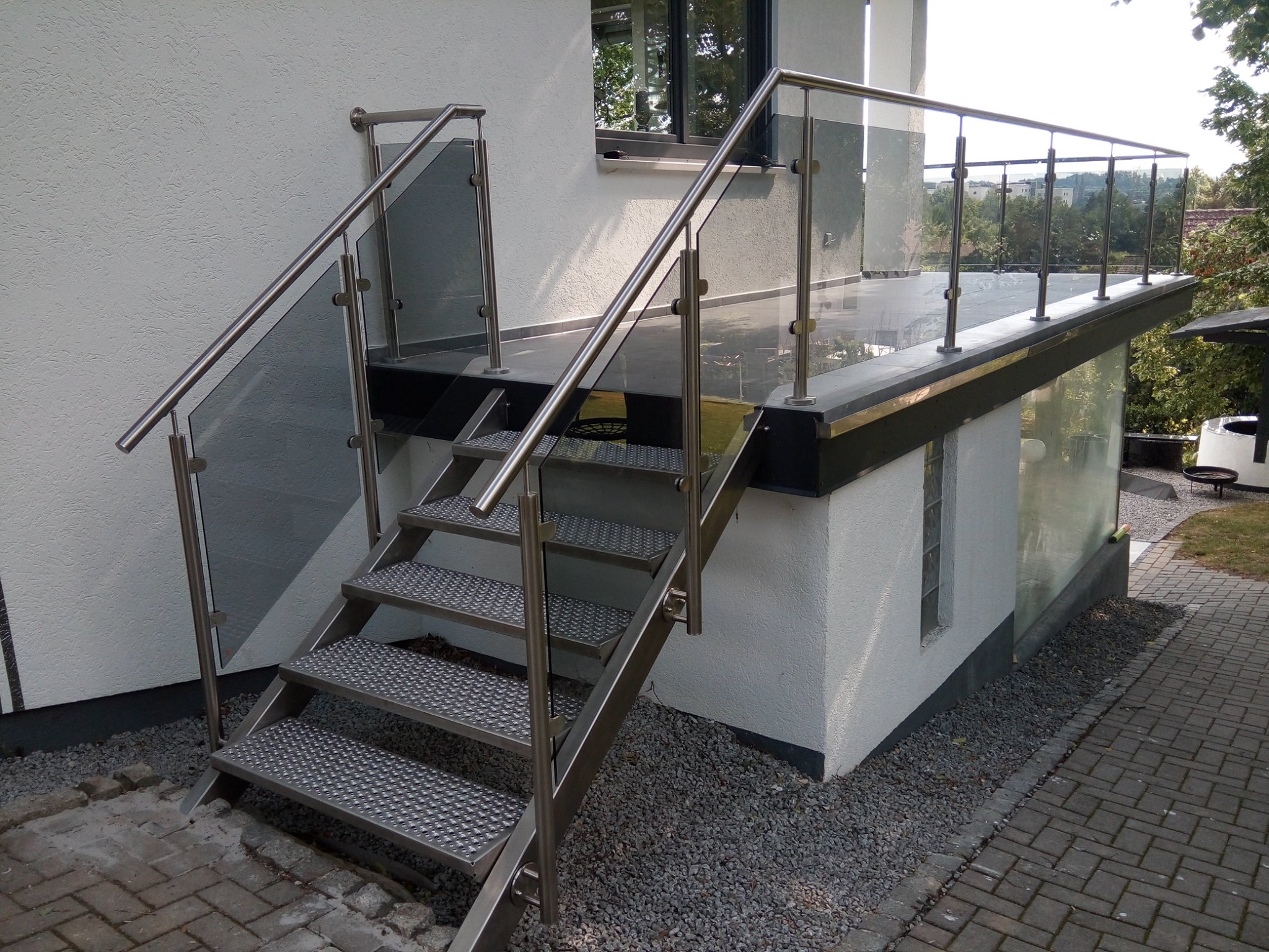 Schody metalowe z balustradą z wypełnieniem szklanym ze szkła z laminatem dymionym
